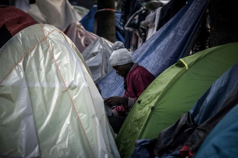 1067570-un-migrant-assis-au-milieu-de-tentes-plantees-dans-une-rue-de-paris-le-27-octobre-2016